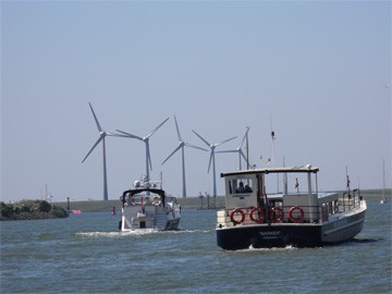 Ijsselmeer met boten en windmolens op achtergrond